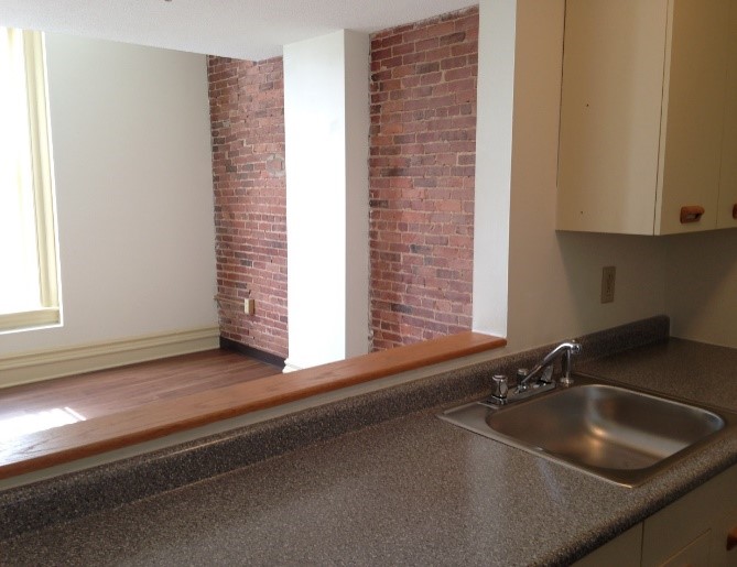 Pass through kitchen to dining room with brick accent walls